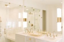 a super elegant white bathroom with chic gold fixtures, handles, knobs and other accents looks very chic