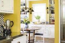 a vintage kitchen with sunny yellow walls, white cabinetry, black and navy touches for a bright contrast and bold looks