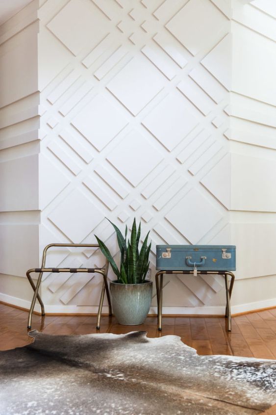 an ultra-modern entryway with white paneled walls that look catchy, add pattern and texture to the space