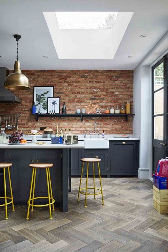 navy grey cabinetry, white countertops, a brick wall and a skylight to refresh the space