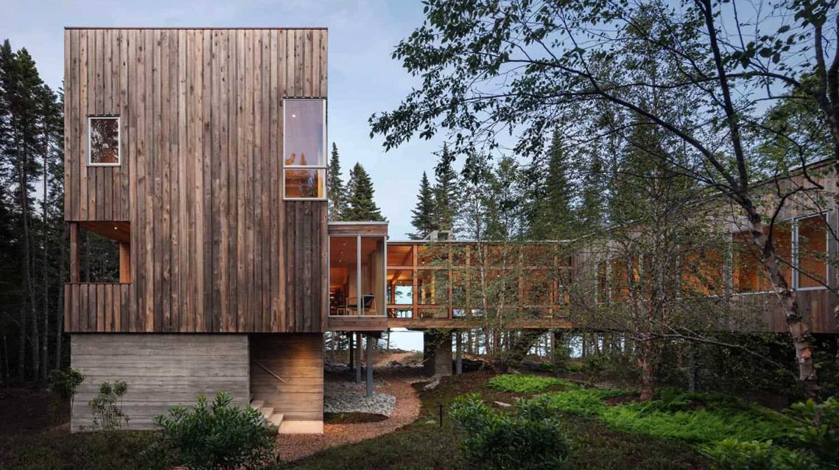 This contemporary treehouse inspired cabin is built on stilts and features a U shape and a central courtyard
