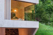 02 The house is clad with light-colored wood, there are glazed walls that allow enjoying the views