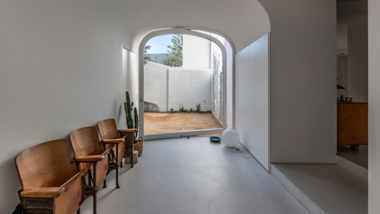 This is an entrance to the inner courtyard, with a pivot door and vintage wooden chairs