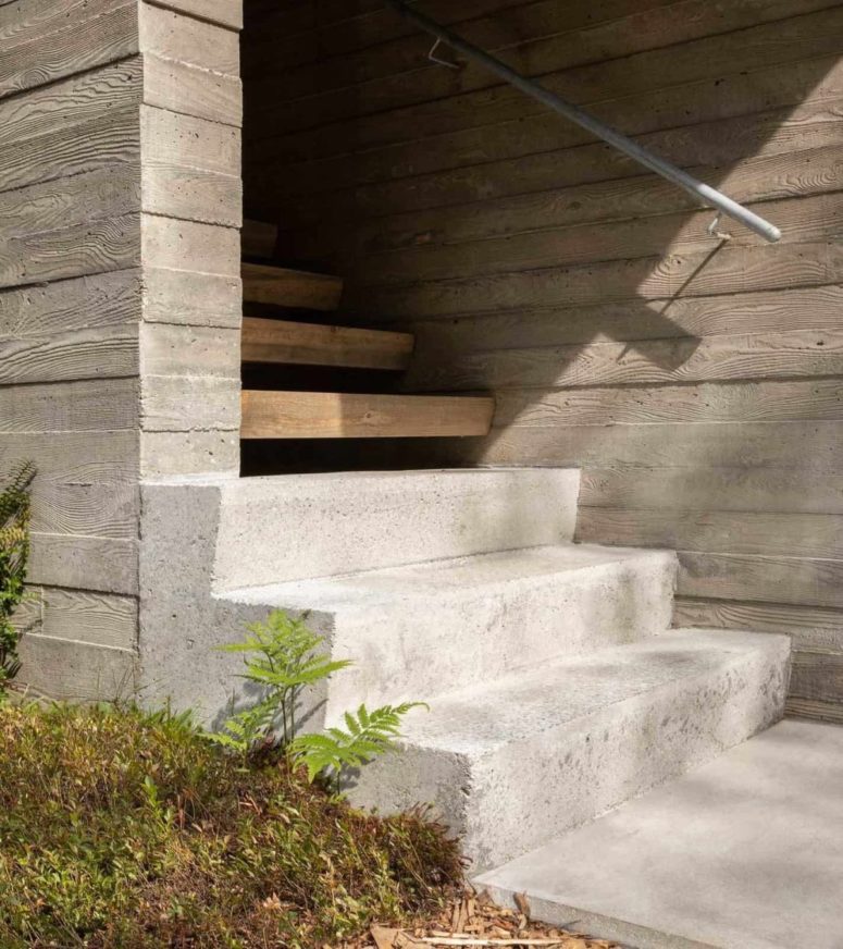The entrance staircase is built of concrete and wood, with metal railing for a modern feel