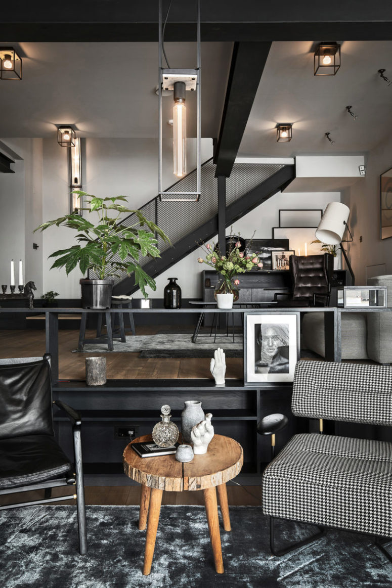 The main space is an open layout with a living room, a kitchen and a dining space done in a monochromatic color palette The main space is an open layout with a living room, a kitchen and a dining space done in a monochromatic color palette