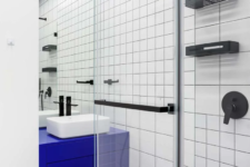 04 Black fixtures highlight the graphic effect and a bright blue vanity adds color