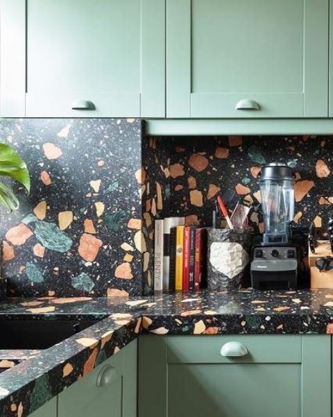 light green kitchen cabinets and a dark terrazzo countertop and backsplash to make the kitchen look outstanding
