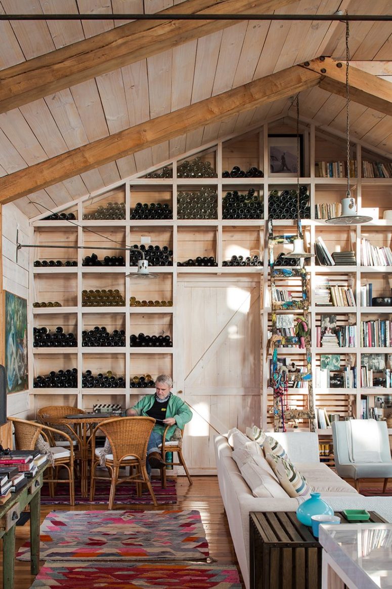 a wall that serves as a wine storage solution One of the walls is taken by a large wine storage unit, there's a small wine tasting nook here with wicker furniture