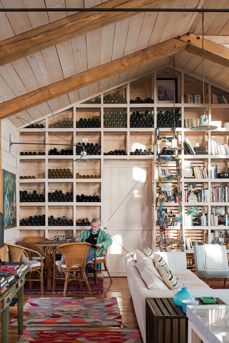 One of the walls is taken by a large wine storage unit, there's a small wine tasting nook here with wicker furniture