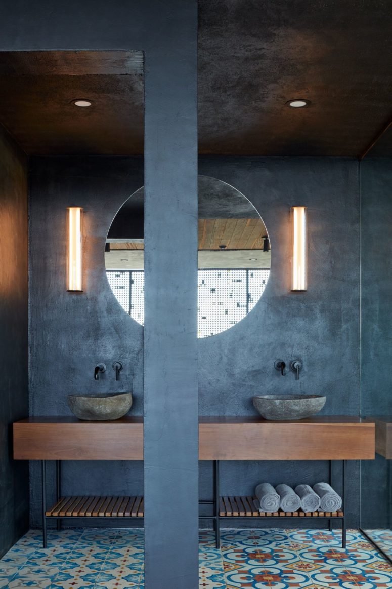 concrete looks great in an industrial bathroom The master bathroom shows off concrete walls, cool colorful tile floors, and rough stone sinks