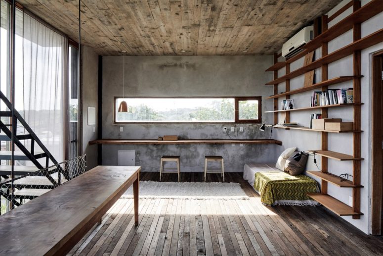 The working space is done with a long desk attached to the wall, an additional table and a daybed