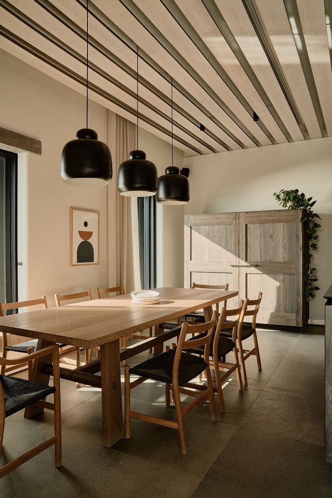 This is an indoor dining space with cool black lamps, black chairs, wooden furniture and black chairs