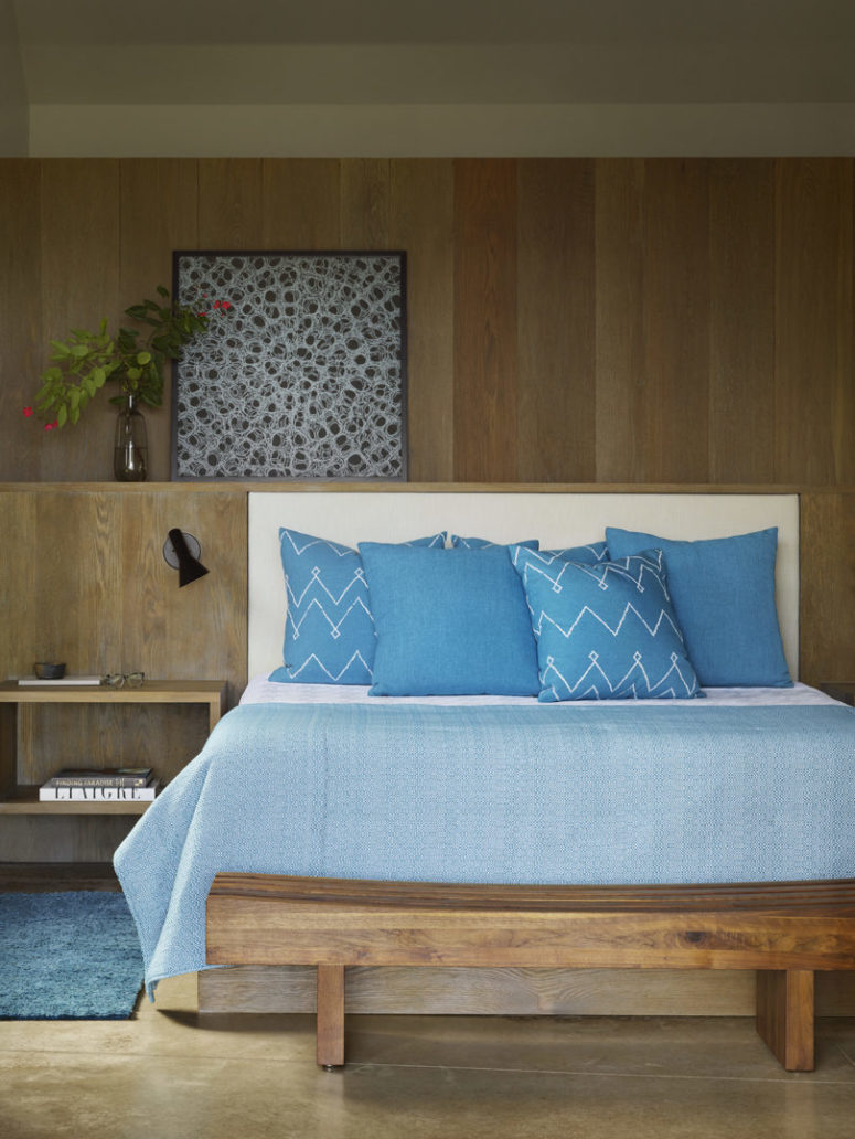 The master bedroom is done with a lot of natural wood, with a built in bed and a bench, with a pretty artwork The master bedroom is done with a lot of natural wood, with a built-in bed and a bench, with a pretty artwork