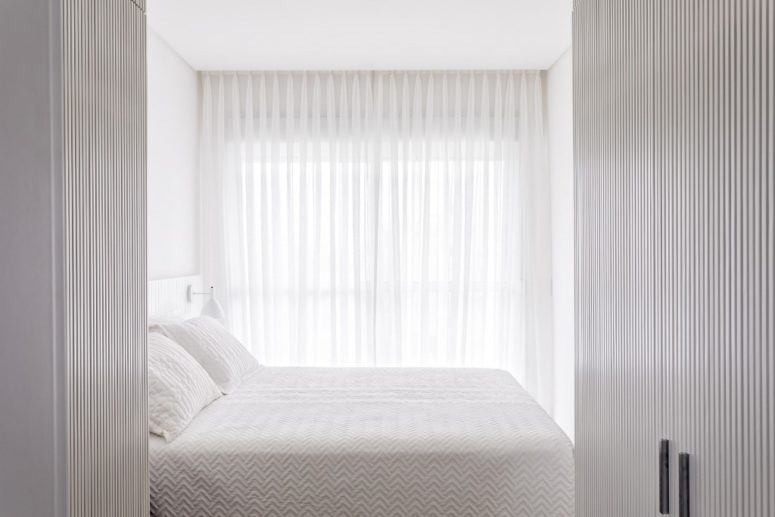 The master bedroom is pure white and rather small, there's some furniture and a gorgeous view