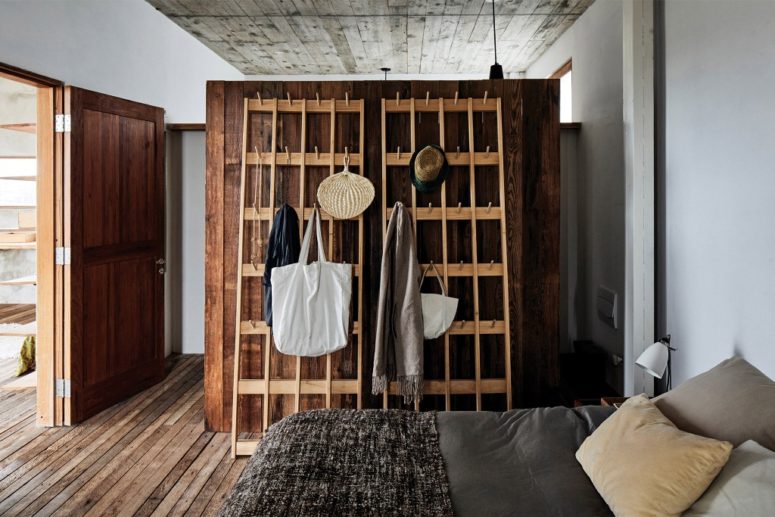 The master bedroom shows off a large wood clad closet and a comfy bed with lots of pillows