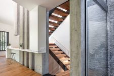 08 The staircase space features glass walls to fill the space with light and make it more airy