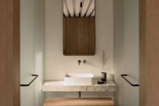 09 The bathroom is minimalist, with a stone vanity, wooden bench and frosted glass clad showers