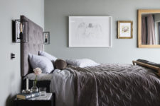 09 The master bedroom is very soothing, with grey walls, a gallery wall, dusty pink textiles and touches of black