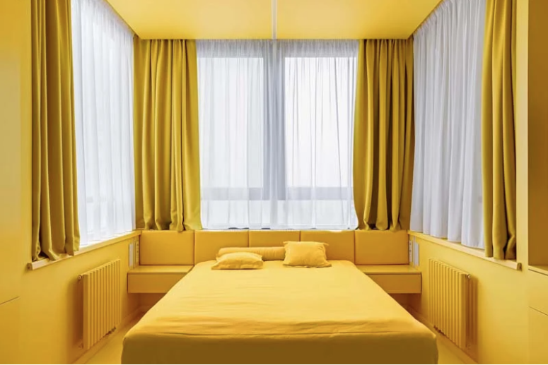 There are several windows to maximize the light, a bed, an upholstered storage headboard and a storage unit
