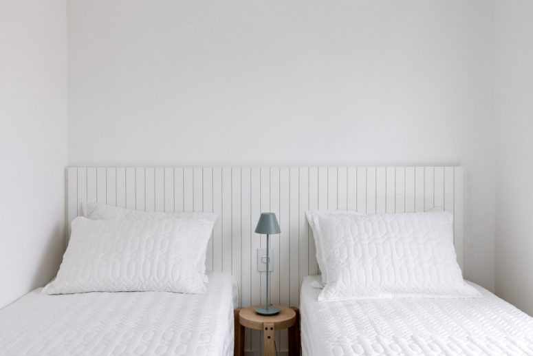 There's also a twin guest bedroom done in white, with two comfy beds and a tiny nightstand between them