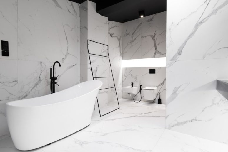 The bathroom is clad with large scale marble tiles, everything is very minimal and refined here