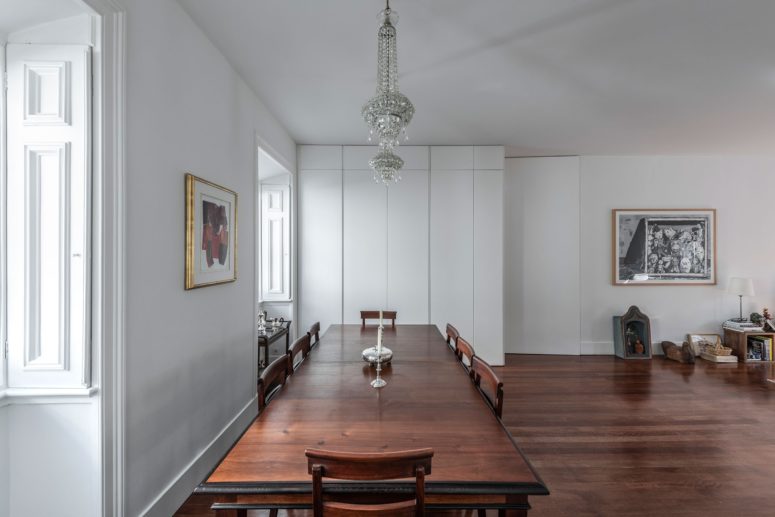 This open layout features a vintage stained dinign set, a crystal chandelier and some sleek white storage units