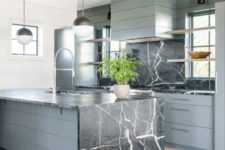 12 a grey wooden kitchen with a black marble backsplash and a matching island with a waterfall countertop