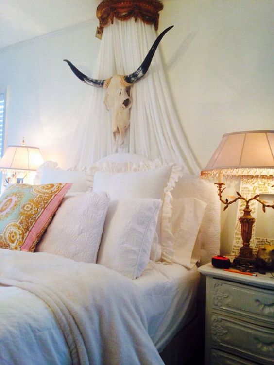 a canopy attached to the wall and an animal skull for a unique eclectic bedroom with a touch of boho