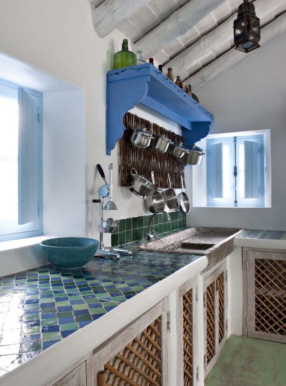a neutral kitchen of light-colored wood, with a stone sink and a bright tile countertop plus a green tile backsplash to wow