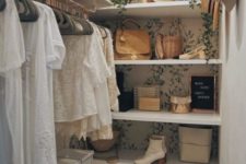 26 a tiny girlish closet with botanical wallpaper, a faux cascading plant, open shelves, some cubbies, holders for hangers and a wooden stool