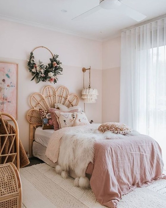 a boho chic bedroom with blush color block walls, pink bedding and rattan furniture is very glam