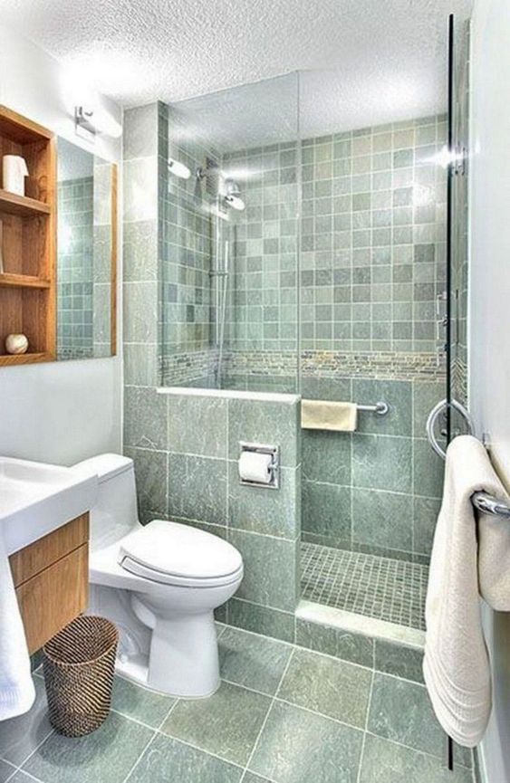 a catchy green bathroom with a small shower space, a stained vanity and a shelving unit, white appliances and white textiles