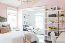 a chic bedroom with pink walls, pink pillows and a blanket, touches of gold and brass for a glam feel