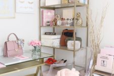 a chic home office with pink books and accessories, with a pink knot pillow and bag and touches of gold