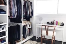 a chic monochromatic cloffice with a white desk, a wooden chair, a makeshift closet and a graphic rug