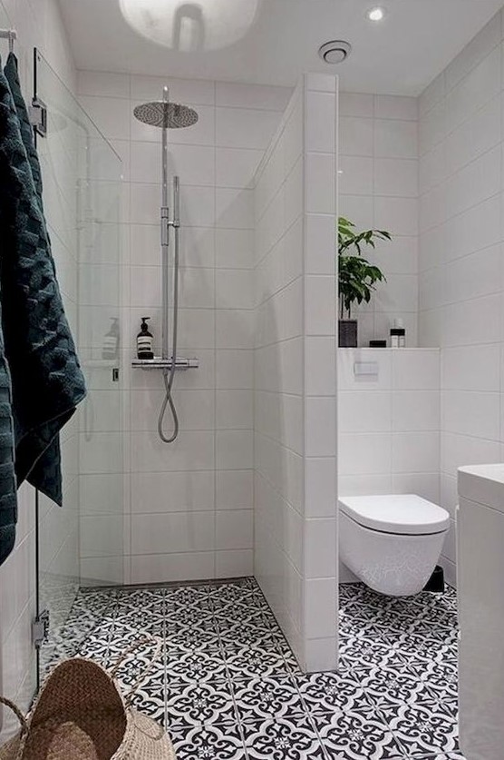 a contemporary bathroom with mosaic tiles, white tiles on the walls, potted greenery and a basket for storage