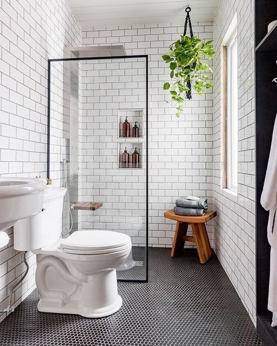 a contemporary bathroom with penny and subway tiles, built-in shelves, a sink and a wooden stool