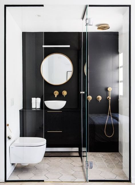 a contrasting small bathroom with a black statement wall and vanity, a shower, a round mirror and a bowl