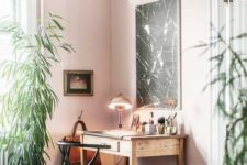 a creative home office with pink walls, wooden furniture, potted greenery and an animal skin rug looks unusual
