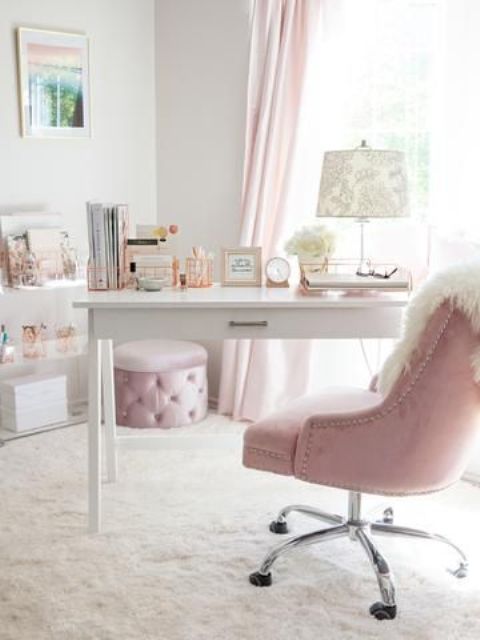 a glam home office in white and light pink, with pink curtains, a glam ottoman and a chair plus elegant prints