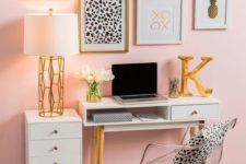 a glam home office with pink walls, an acrylic chair, a pretty gallery wall in gold, black and white