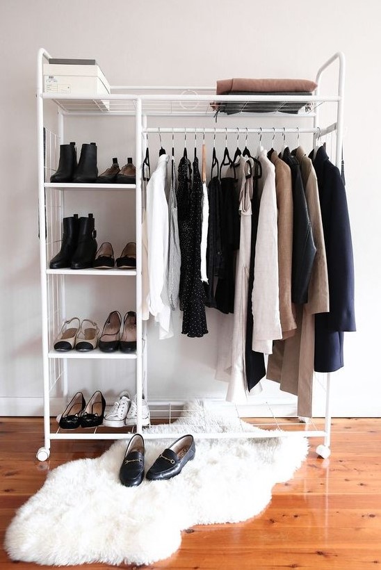 a minimalist makeshift closet with shoe shelves, a box and some space for clothes hangers