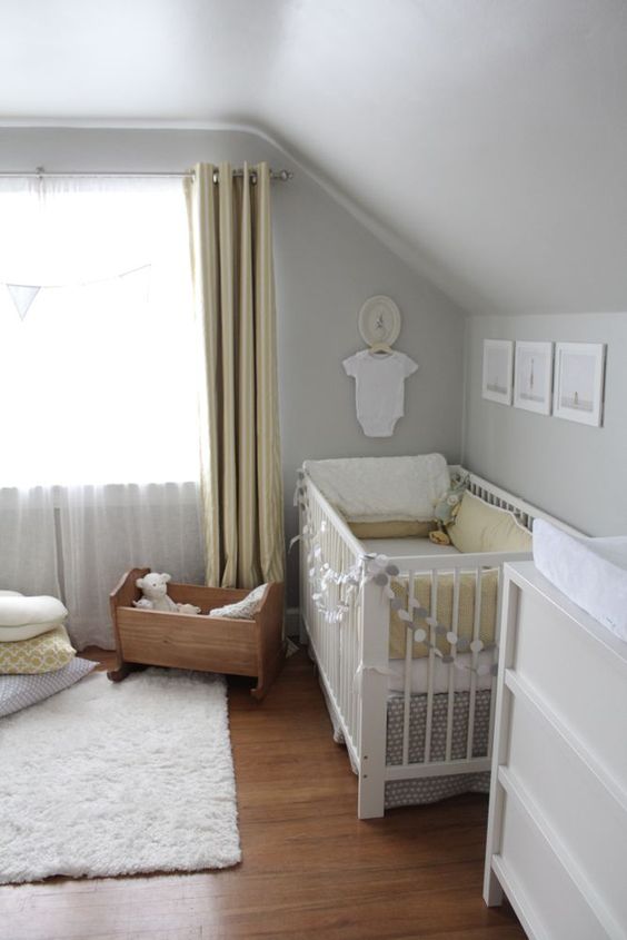 a neutral and peaceful nursery with dove grey walls, yellow curtains, grey and yellow bedding and a cute gallery wall