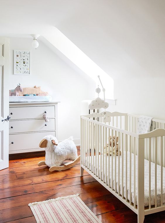 a neutral attic nursery with simple and casual furniture, muted and printed textiles plus lots of cute toys