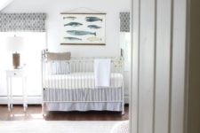 a neutral nautical attic nursery with light blue textiles, a fish artwork and some simple white furniture is easy to make