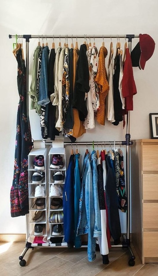 a simple makeshift closet with a double hanging shoe shelf and a dresser for small things next to it is a cool idea