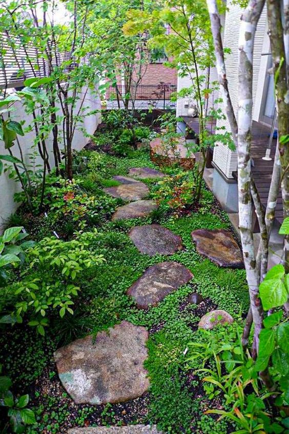 a small Japanese-inspired garden with rocks as pavements, greenery, shrubs and a couple of trees is very peaceful