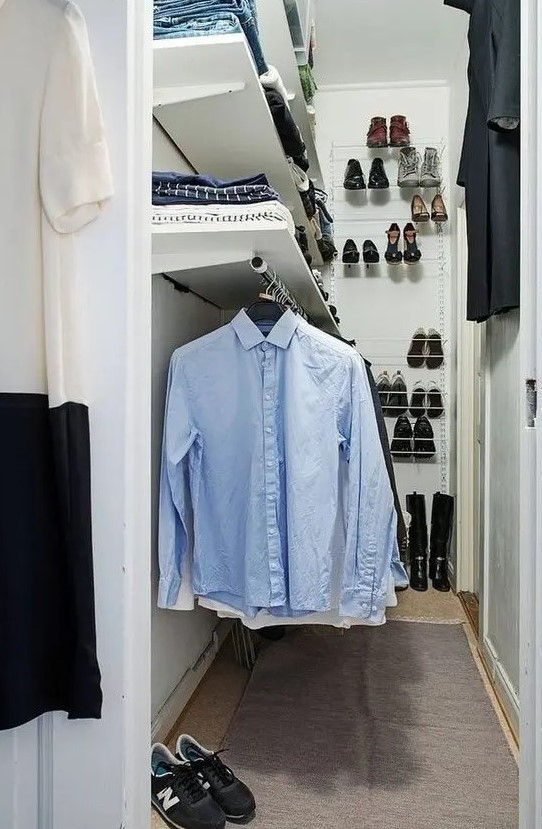 a small and narrow closet in white, with open shelves and railing, shoe shelves attached to the wall is a lovely idea for a small home