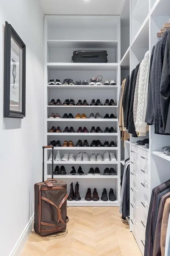 a small and narrow walk-in closet with open shelving and storage compartments, drawers and an artwork is a great space
