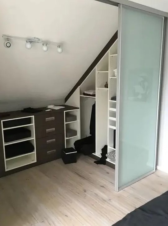 a small attic spot turned into a walk-in closet, with built-in shelves, dressers and glass sliding doors is a cool idea